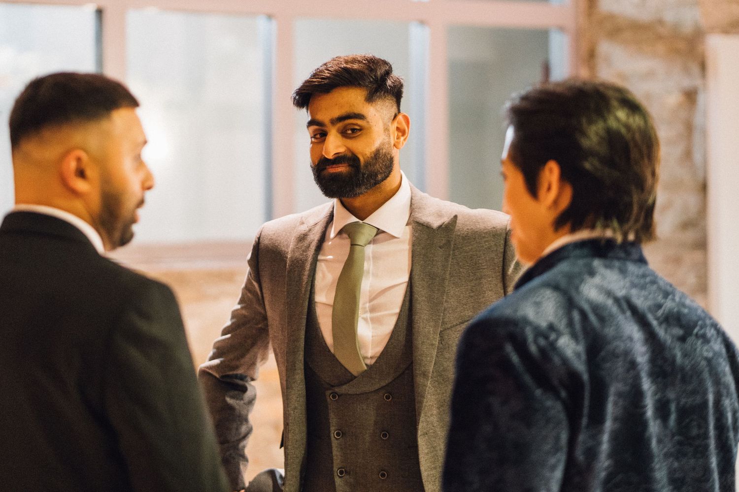 Group of guests mingling and conversing at formal indoor event.