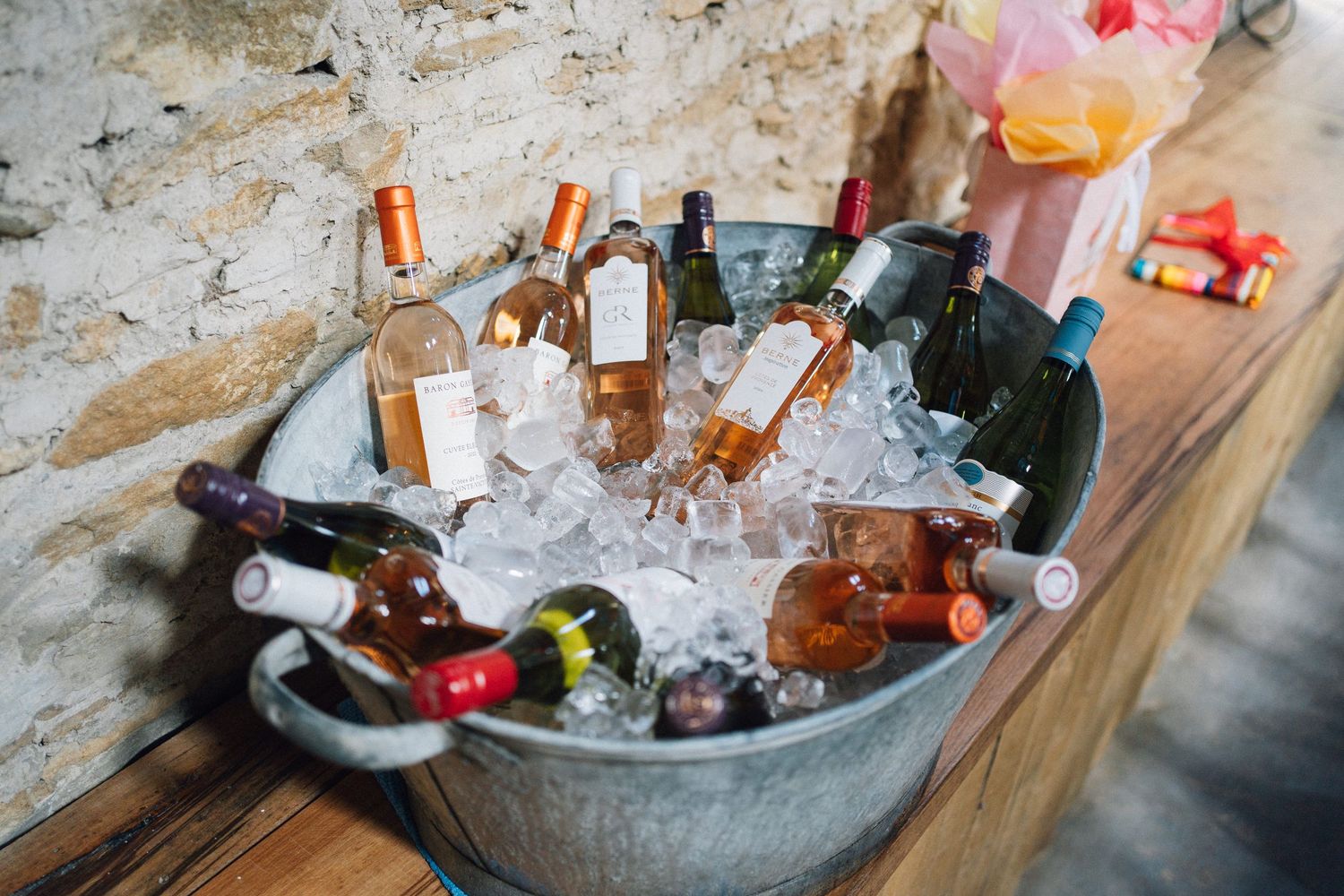 Ice bucket filled with assorted drinks and beverages at an outdoor party.