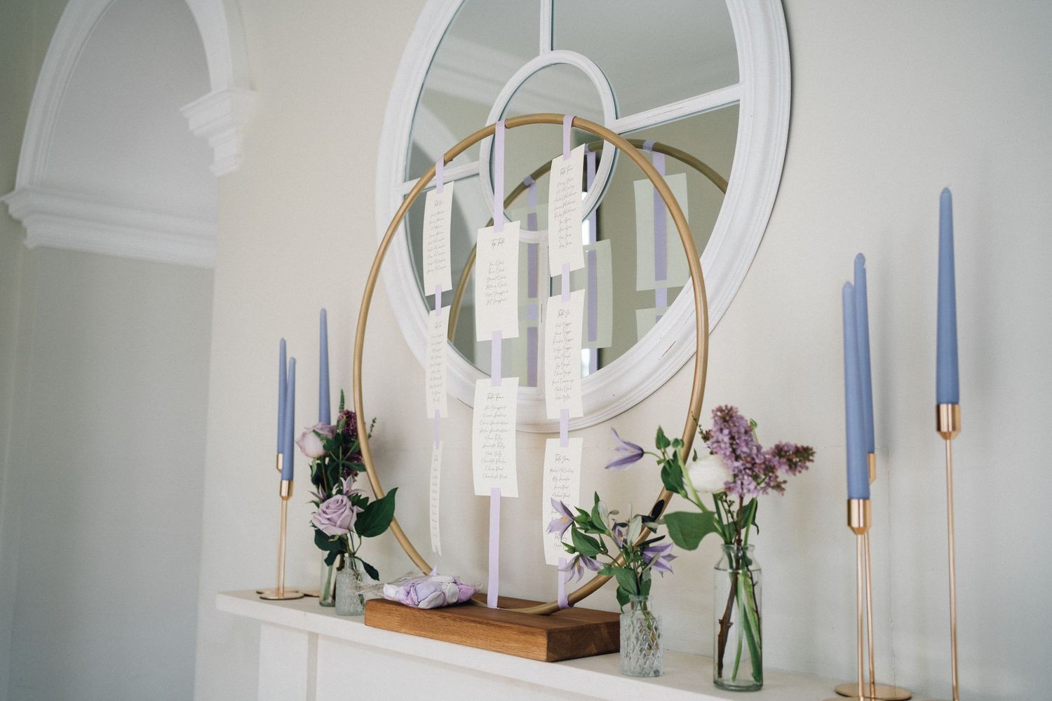 Elegant white interior decor featuring glass vases with floral arrangements and hanging pendant lights.