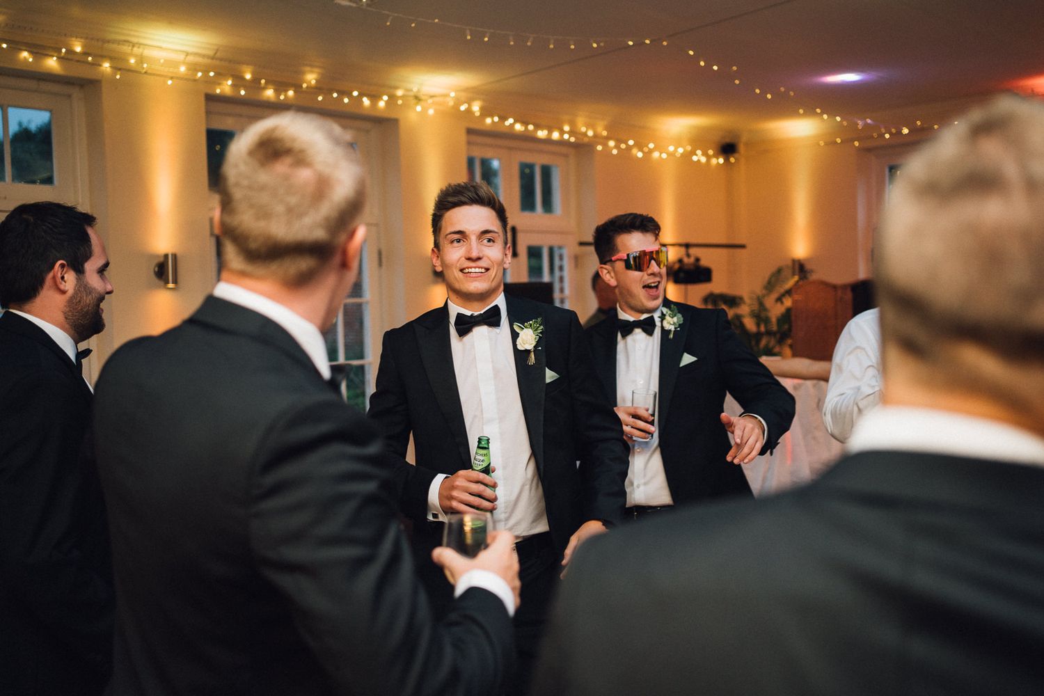 Guests in formal attire mingle and socialize during an elegant evening wedding reception.