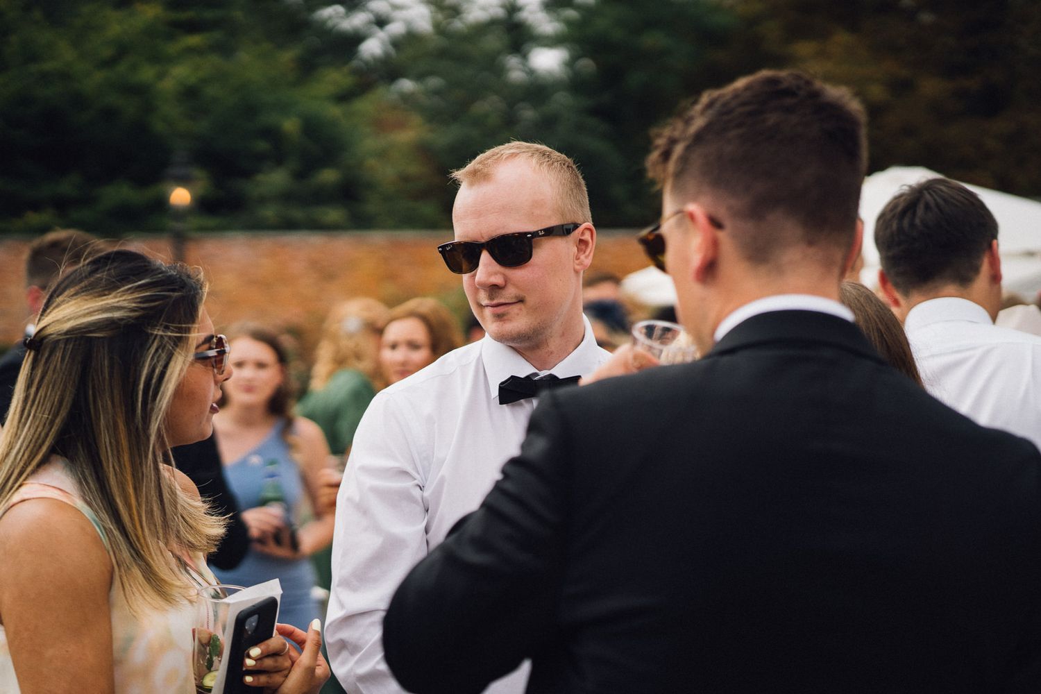 Wedding guests mingle during an outdoor summer reception.