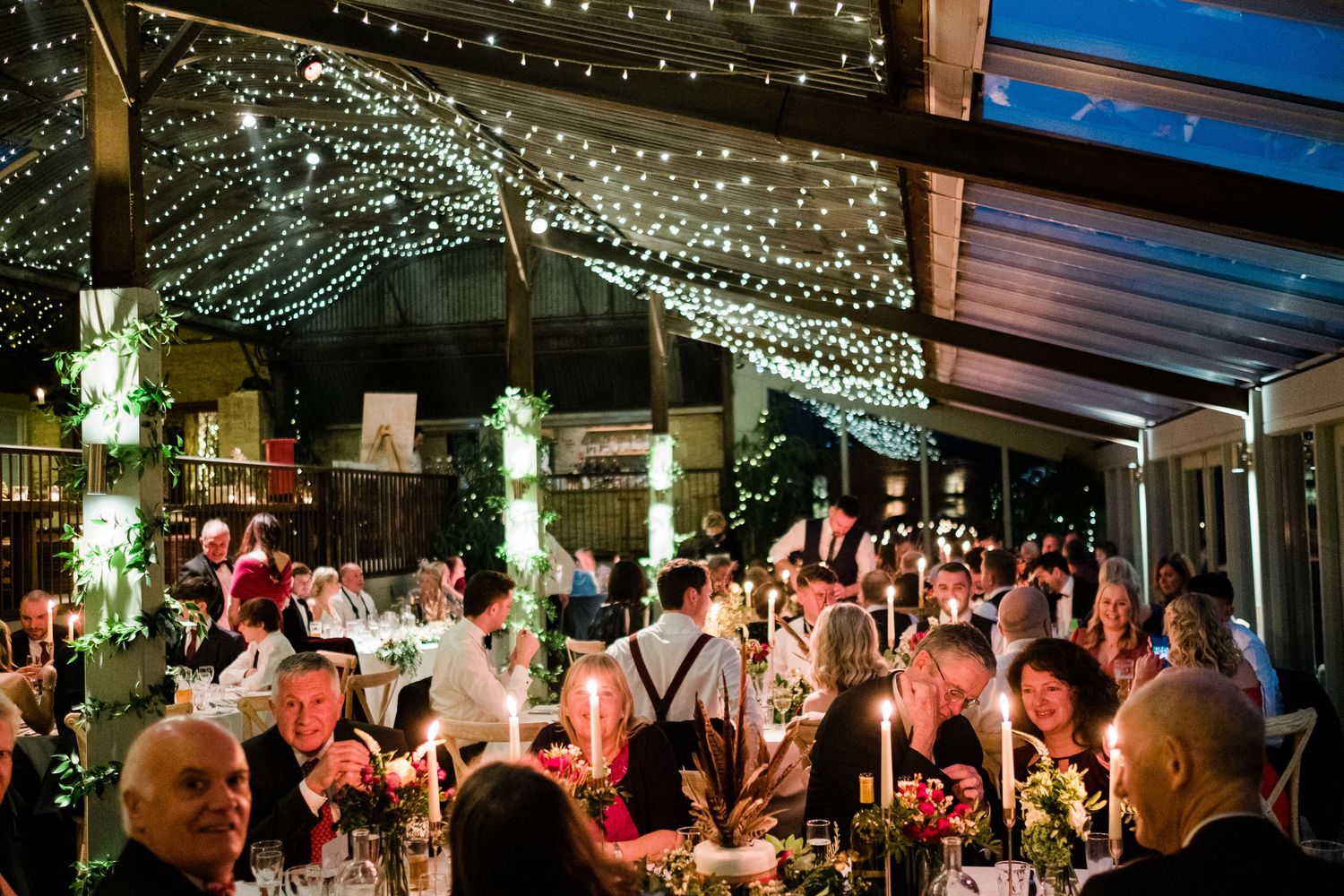 Wedding venue illuminated with string lights creating a magical outdoor atmosphere.