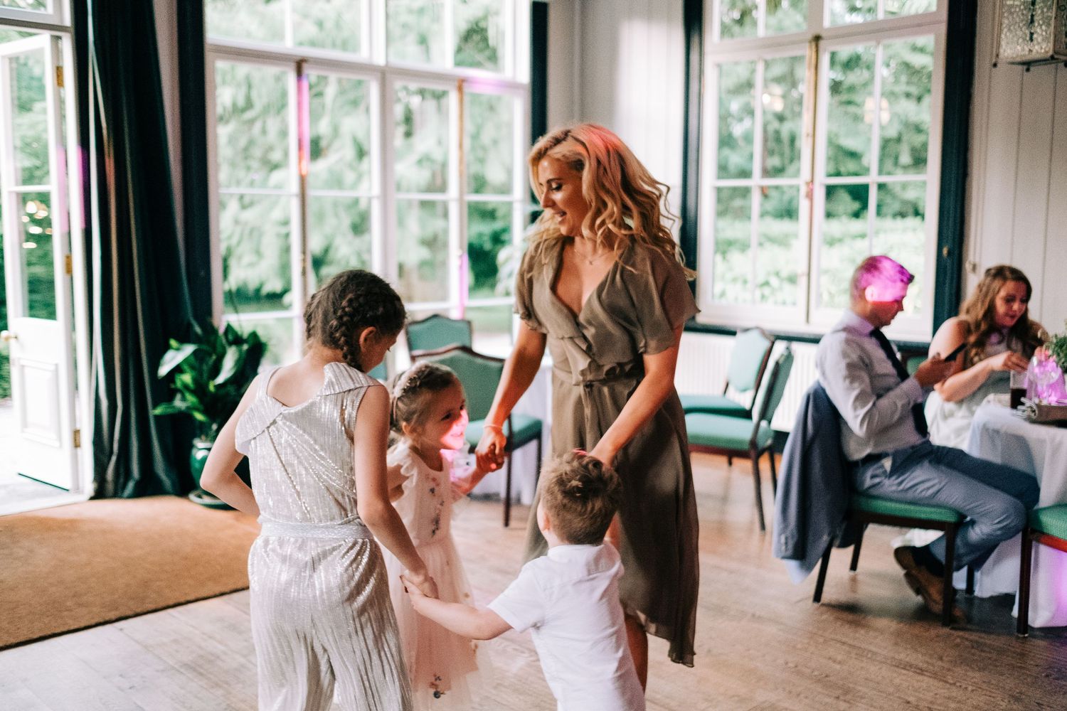 Bright sunlit room with large windows and wedding preparations underway.