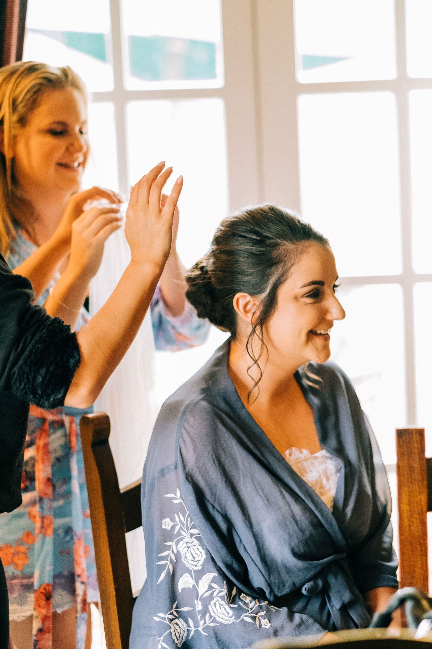 People laughing and getting ready in a bright sunlit room.