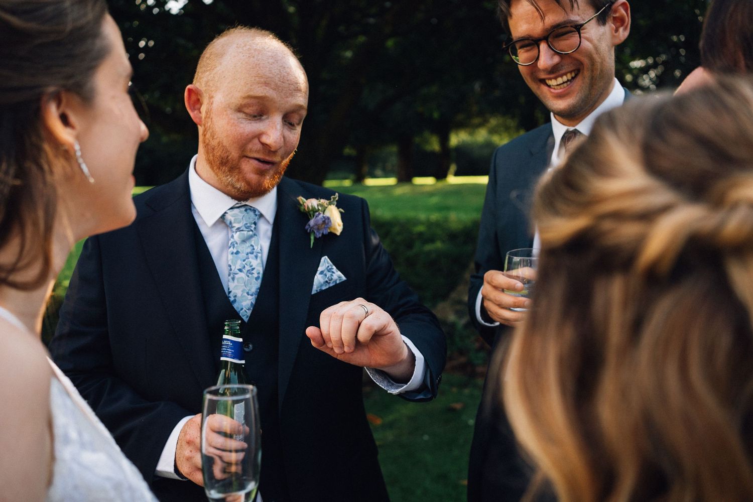 Wedding guests enjoying drinks and conversation at an outdoor celebration.