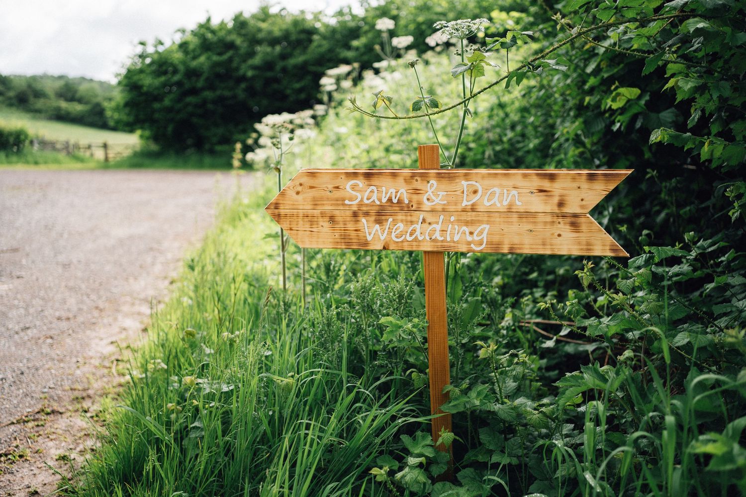 Wooden directional signs point the way along a lush green garden path.