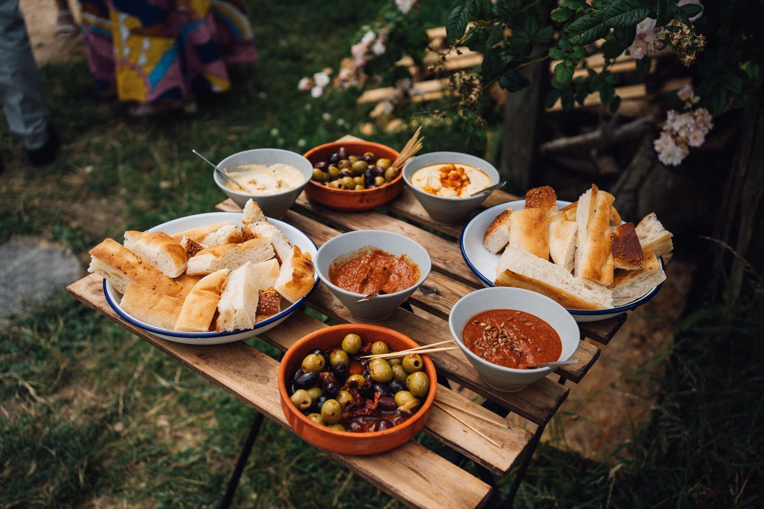 Mediterranean appetizer spread with olives, dips and bread served on wooden pallet.