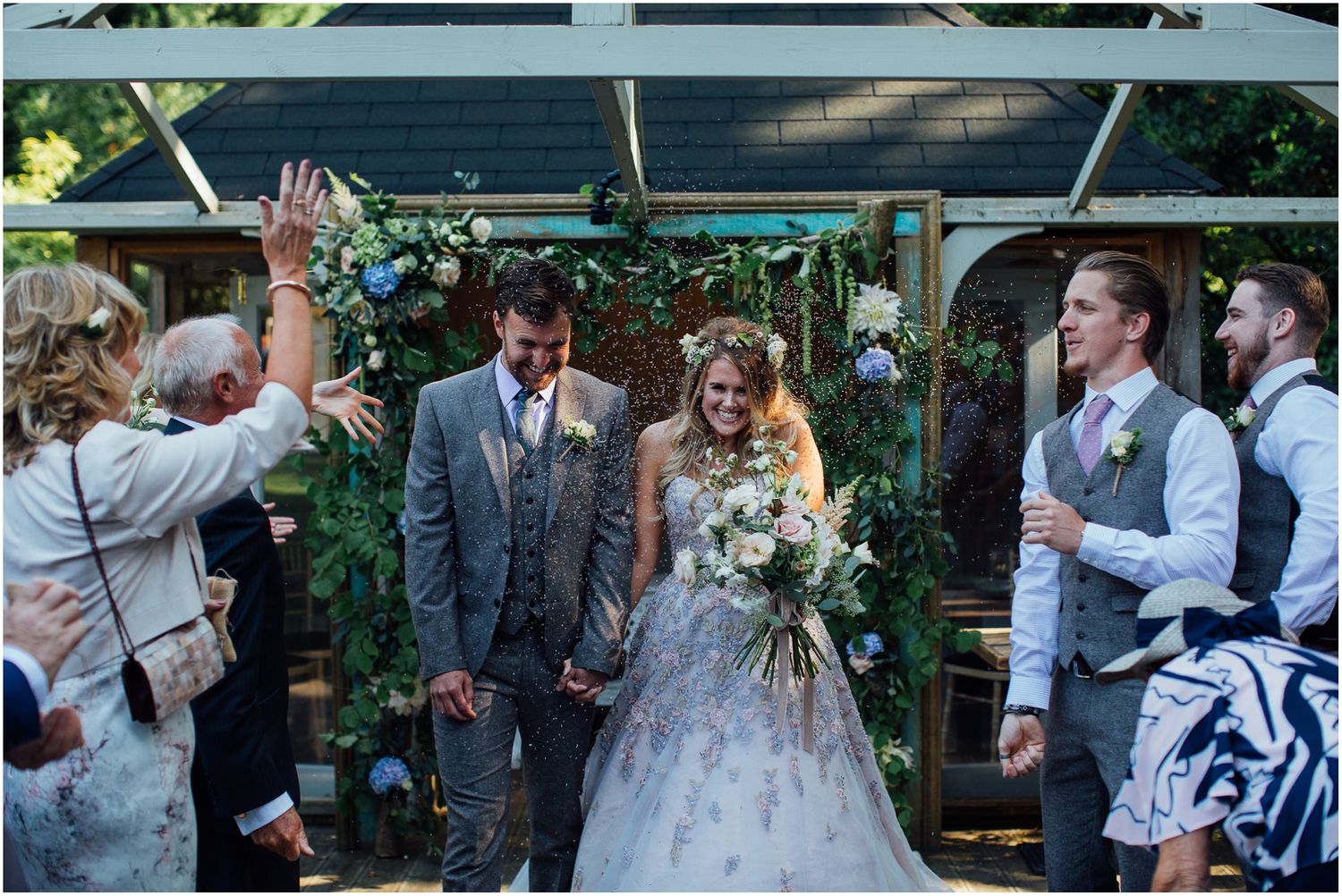 Wedding celebration with guests and couple mingling in an outdoor garden venue.