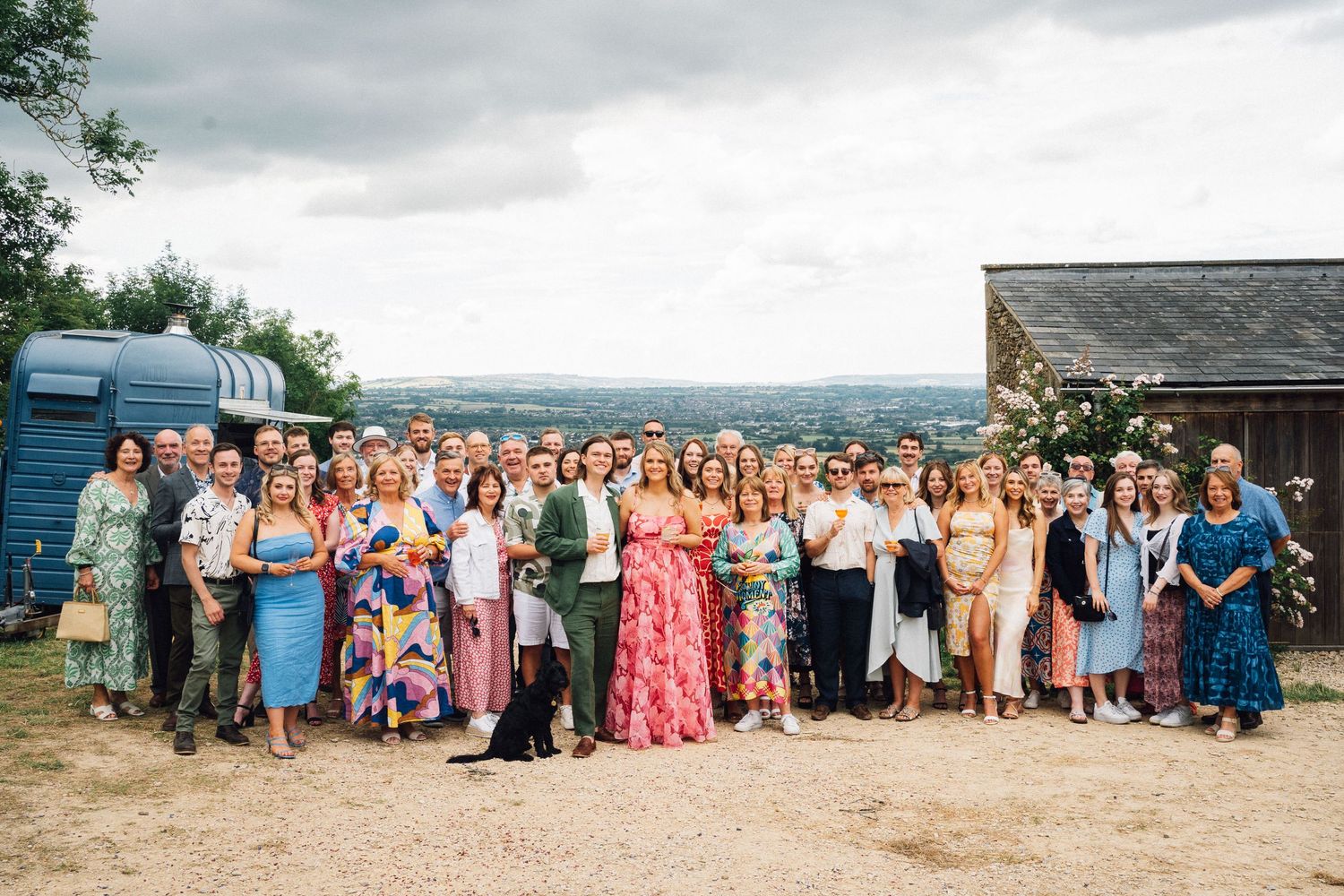 Large group wedding photo with guests lined up outdoors.