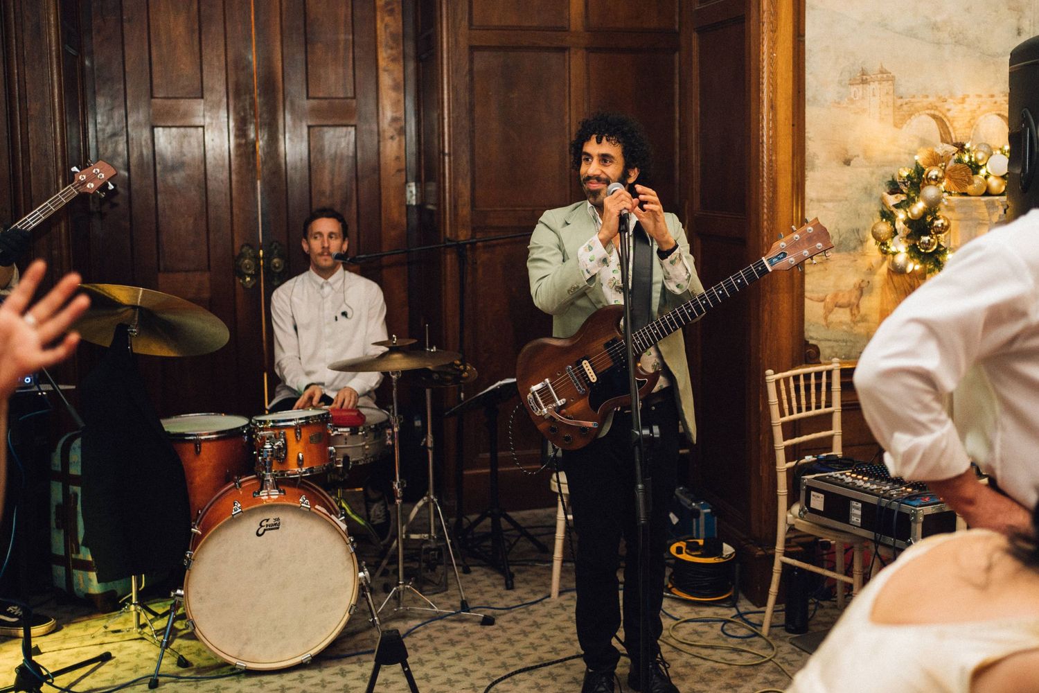 Live wedding band performing on stage with instruments and musicians in formal attire.