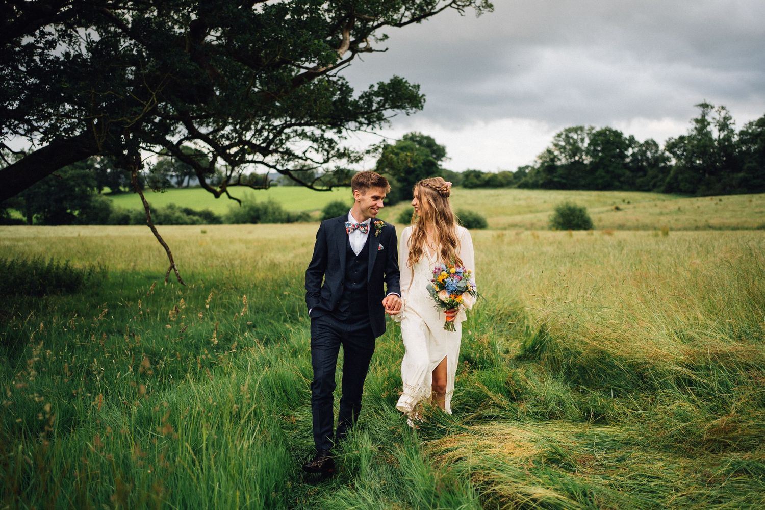 Romantic wedding portraits taken in a rustic field with tall grass.