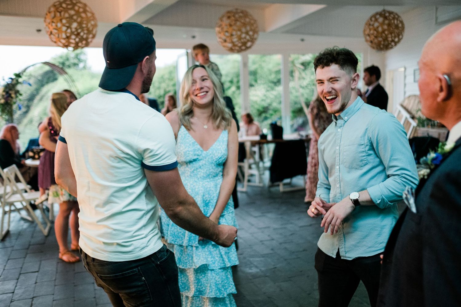 Wedding celebration with guests dancing and socializing in a modern venue.