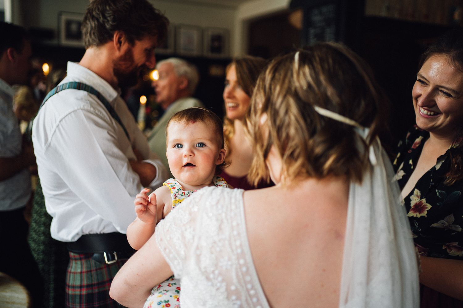 A series of candid wedding reception photos showing guests dancing and celebrating together at an indoor venue.