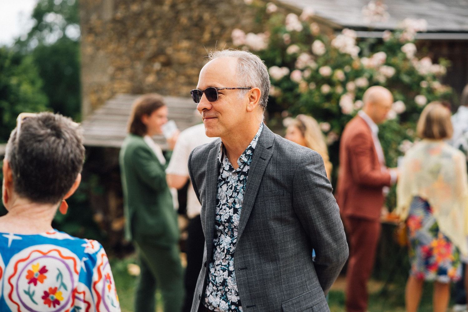 Wedding guests mingling at an outdoor garden reception.