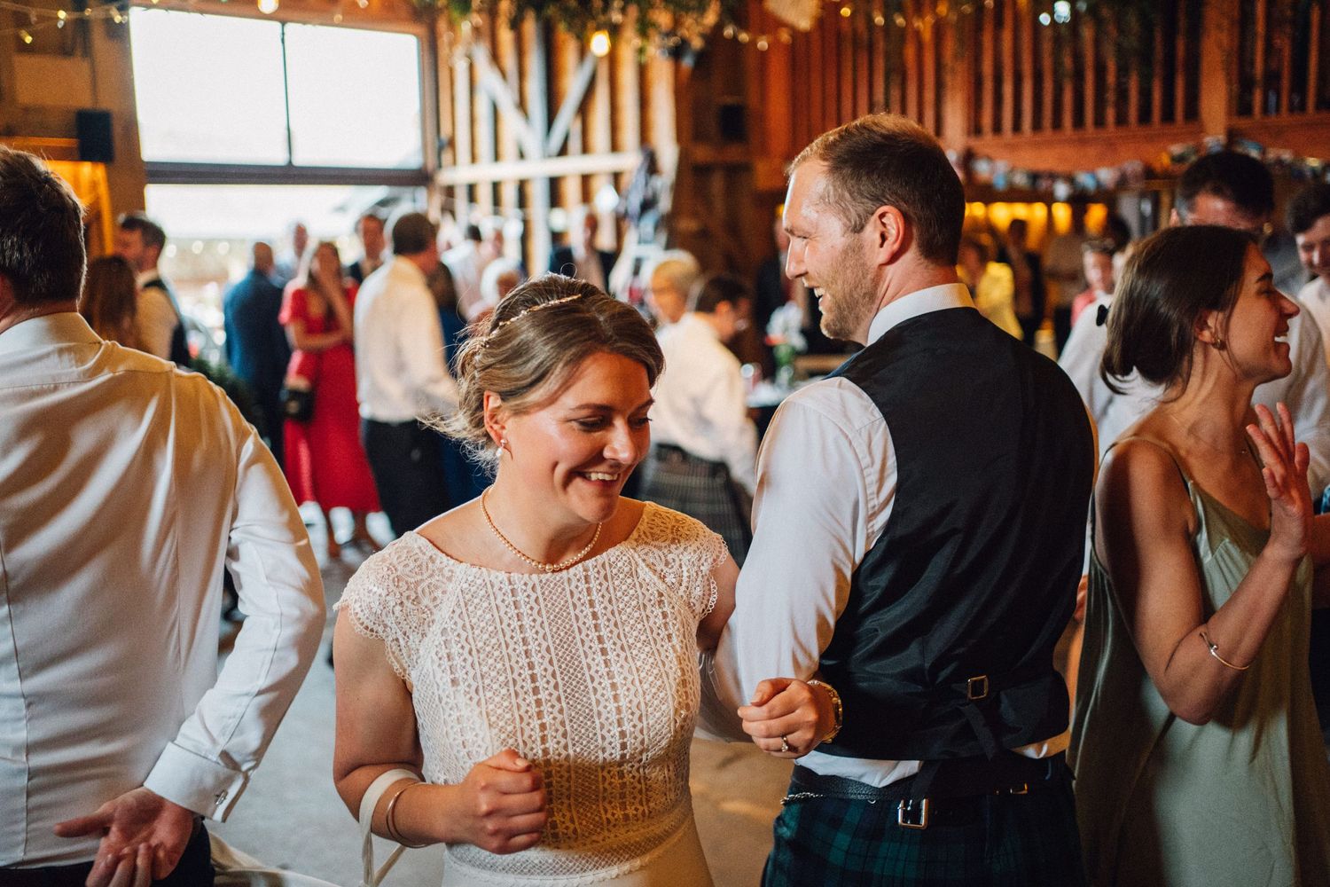 Candid moments of wedding guests laughing and socializing during reception celebration.