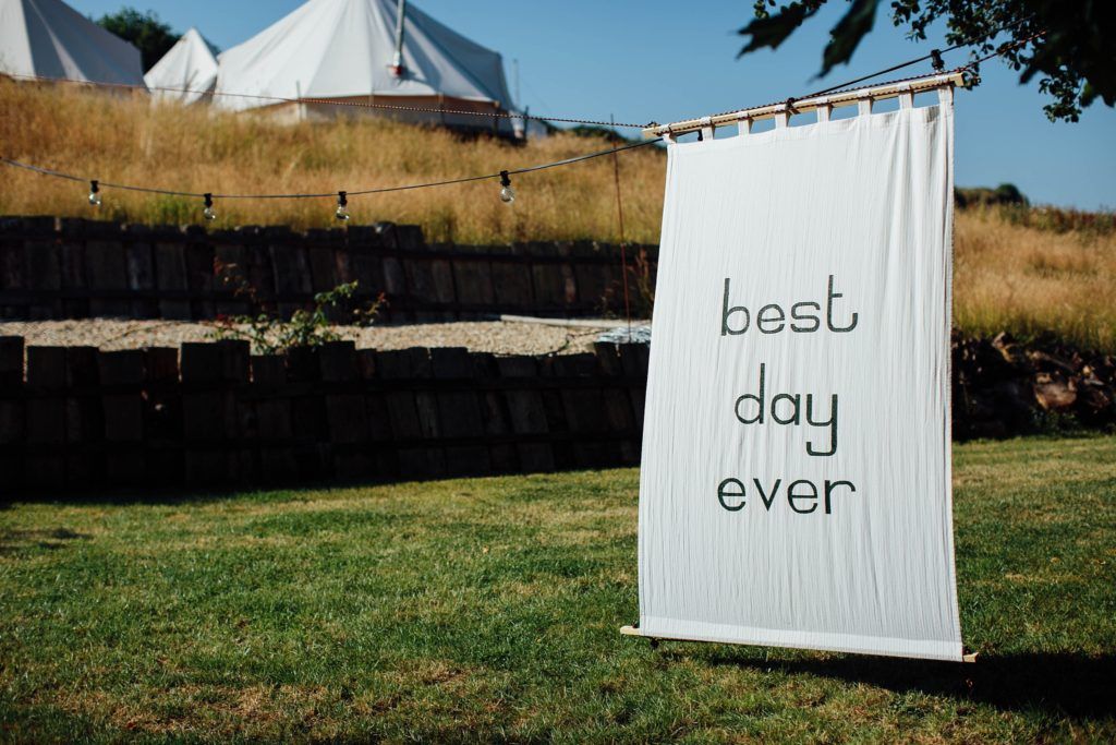 White decorative banners displayed outdoors against a natural landscape backdrop.