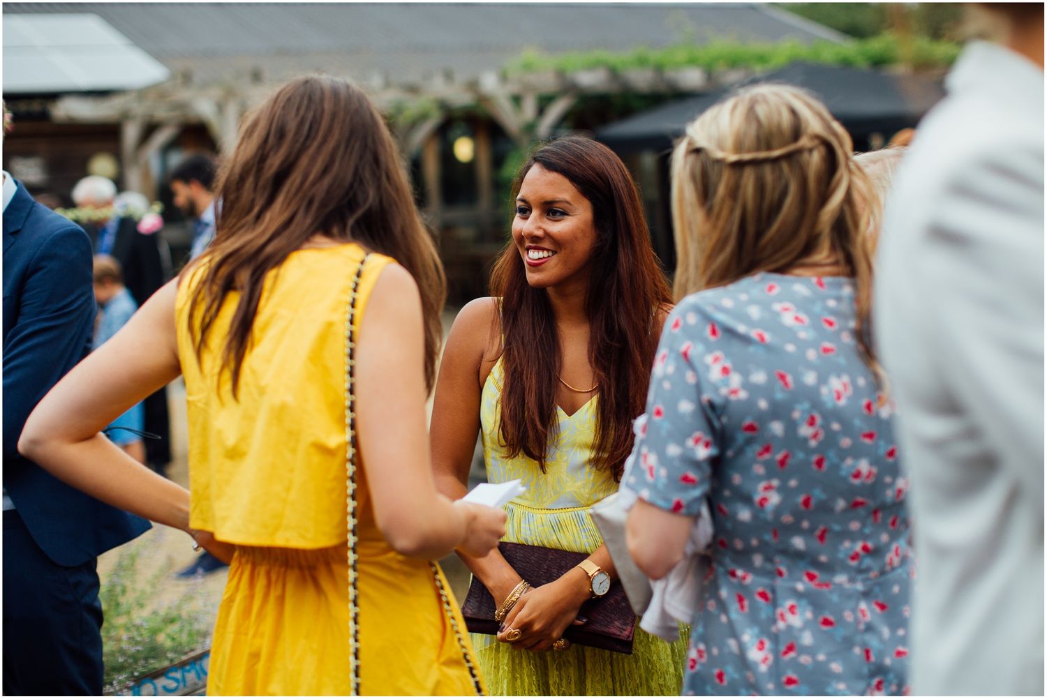 Group of guests in summer attire enjoying an outdoor celebration.
