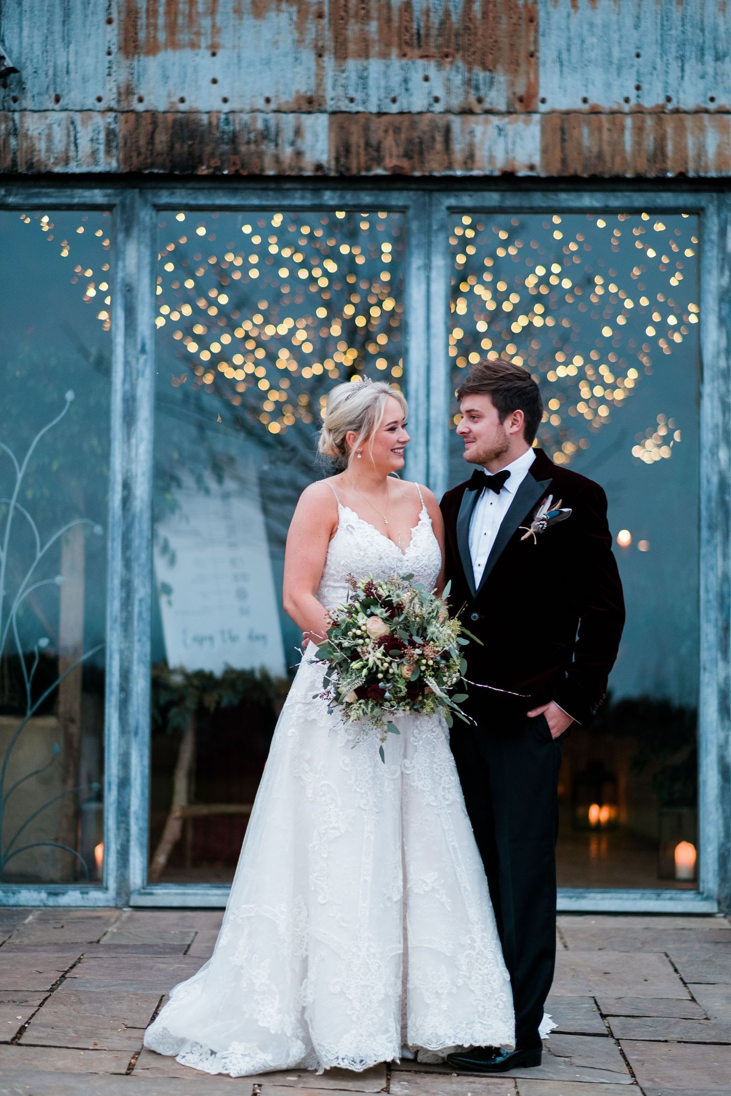 Romantic wedding sequence with couple posing against blue industrial backdrop with fairy lights.