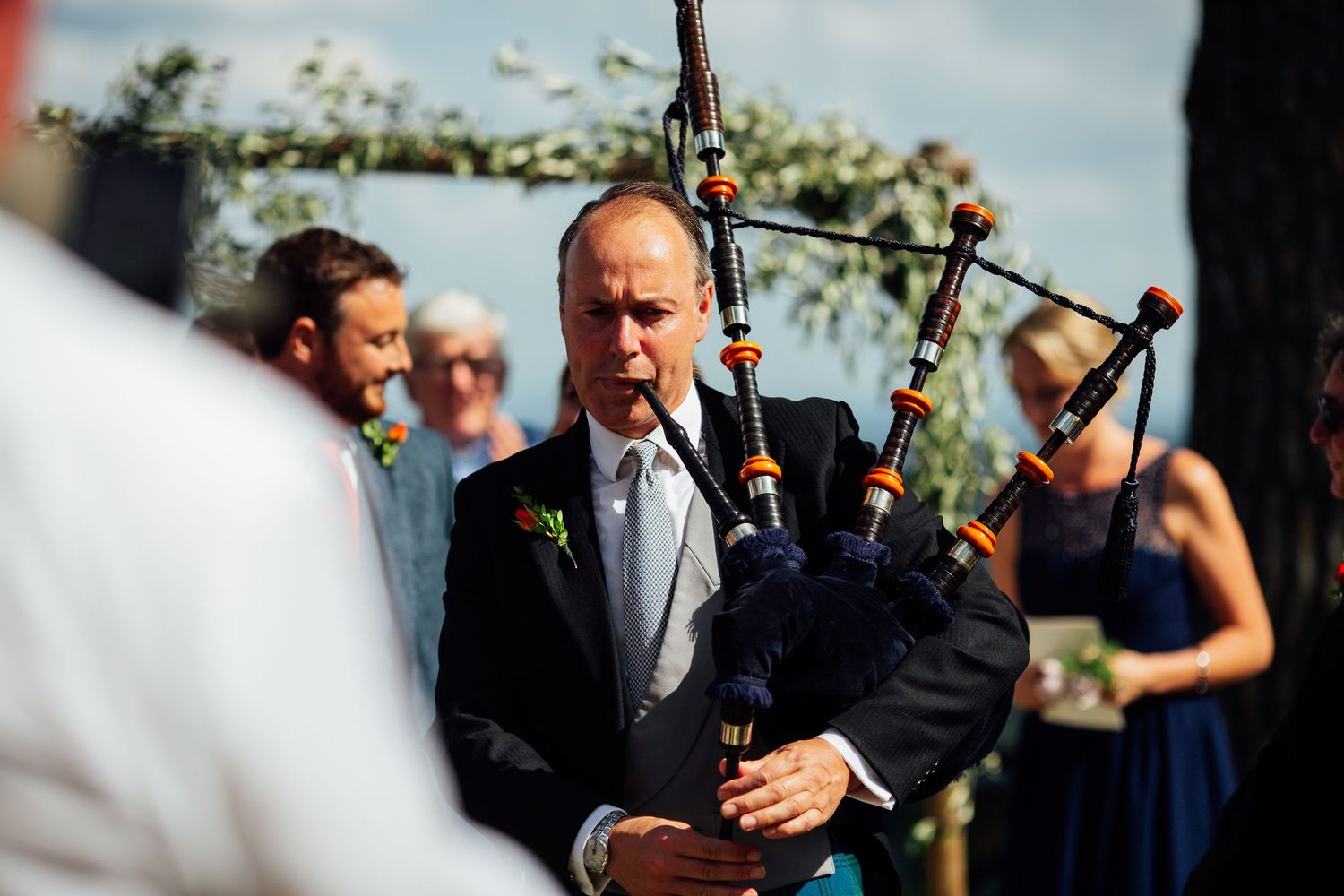 Wedding ceremony musicians performing outdoors under blue skies.