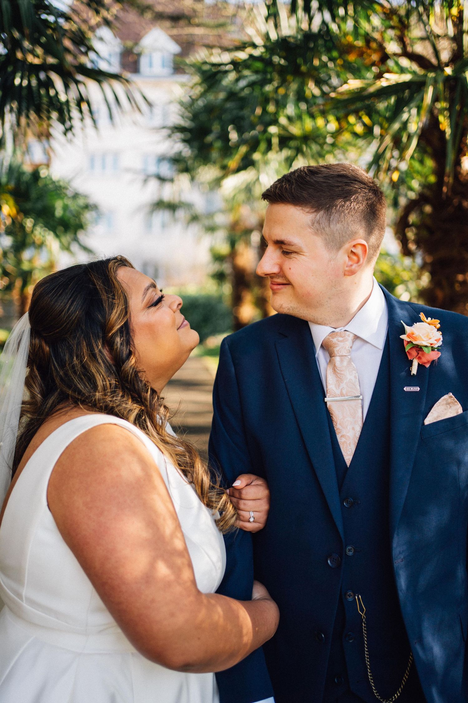 A romantic wedding couple shares tender moments in a series of candid photos under palm trees.