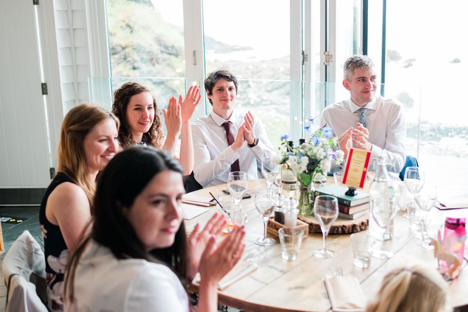 Wedding reception dining room with panoramic ocean views and elegant table settings.
