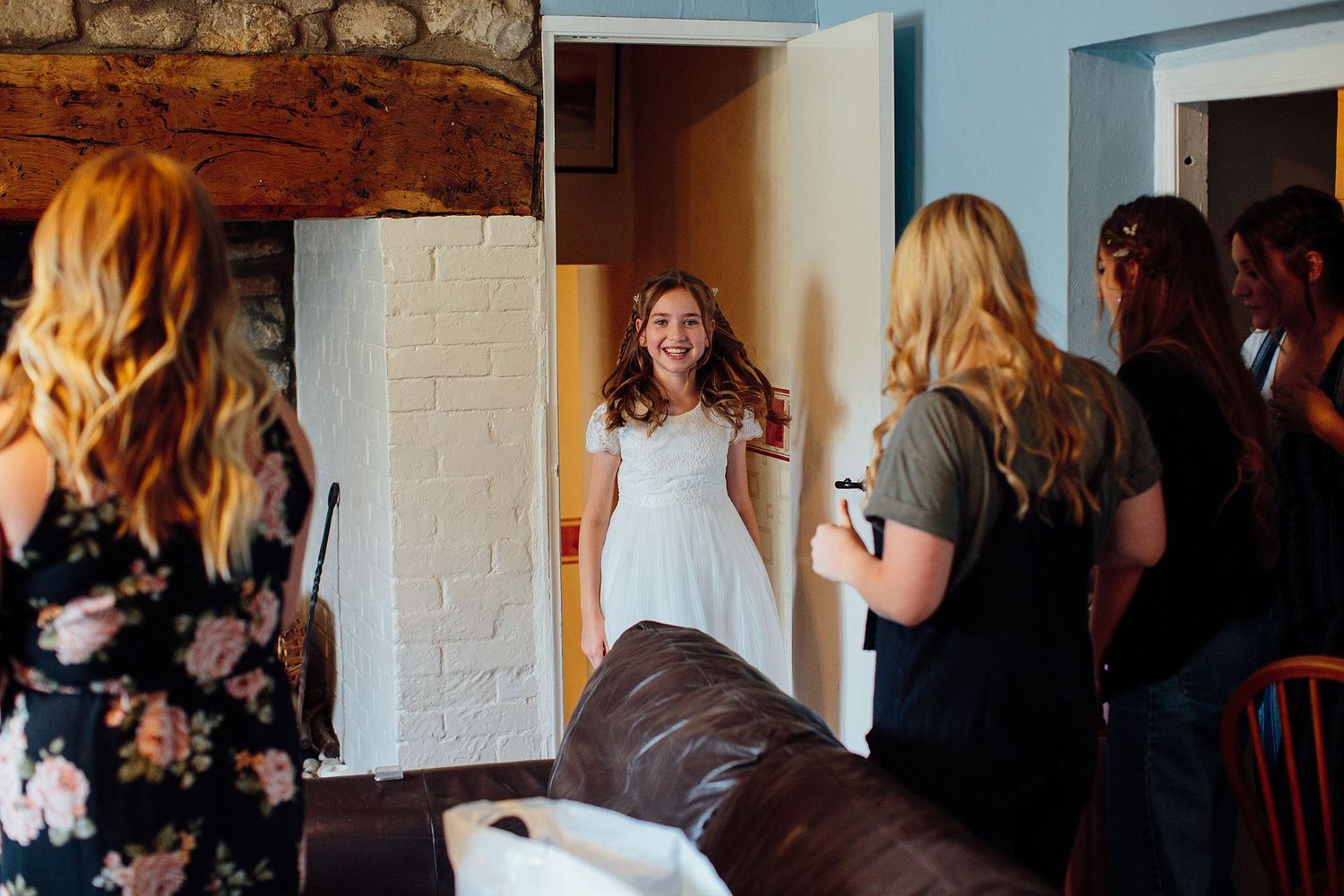 People socializing in a dimly lit room with white painted walls.
