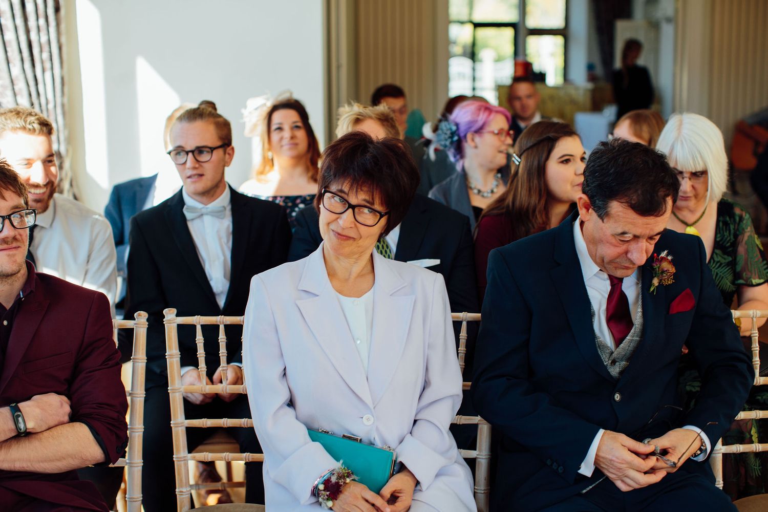 Wedding guests gathered in formal attire during an indoor celebration.