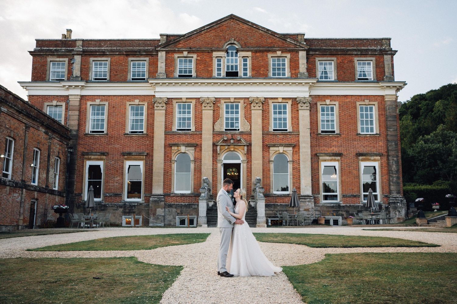 Grand Georgian mansion with red brick facade serves as elegant wedding venue.