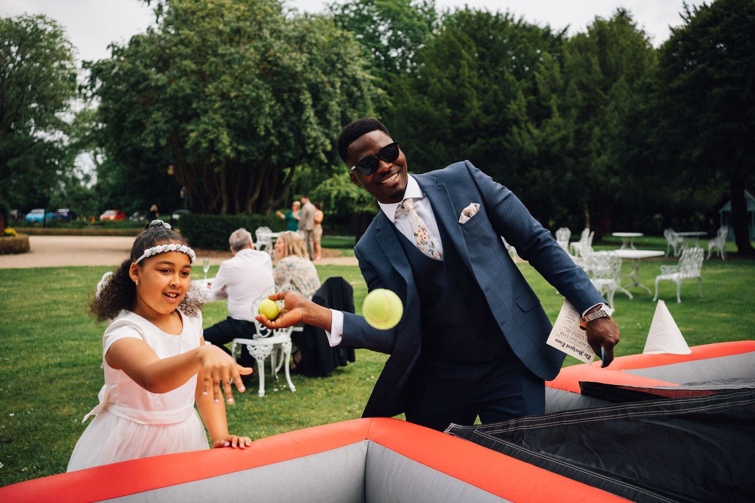 Wedding party playing outdoor games on a sunny summer day with red and white decor.