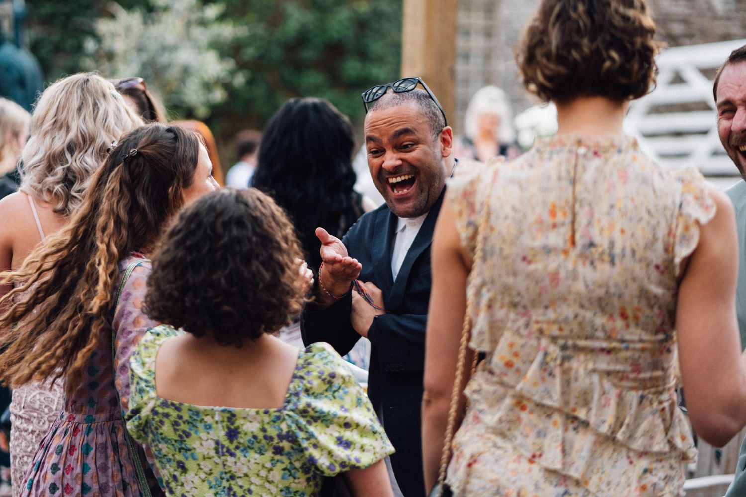 A lively outdoor gathering shows people engaged in animated conversation at a social event.