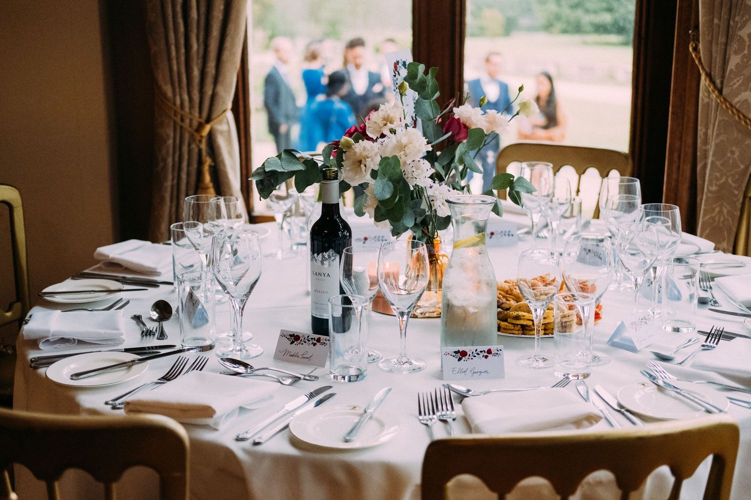 Wedding reception venue with elegant table settings and natural light streaming through windows.