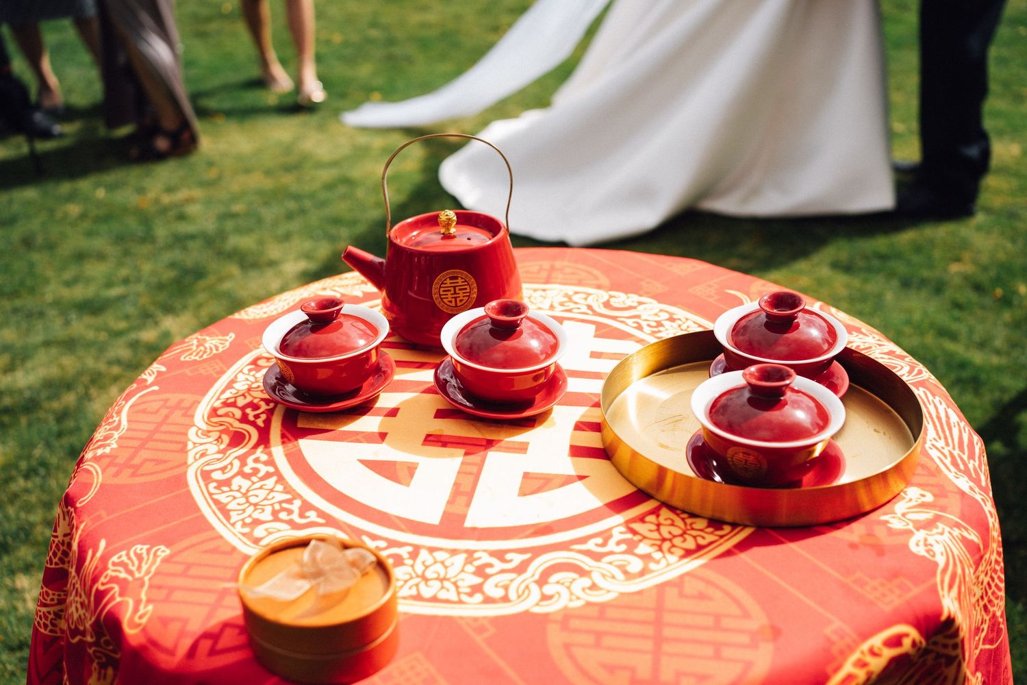 Red traditional Chinese tea ceremony pots arranged on a decorative table setting.