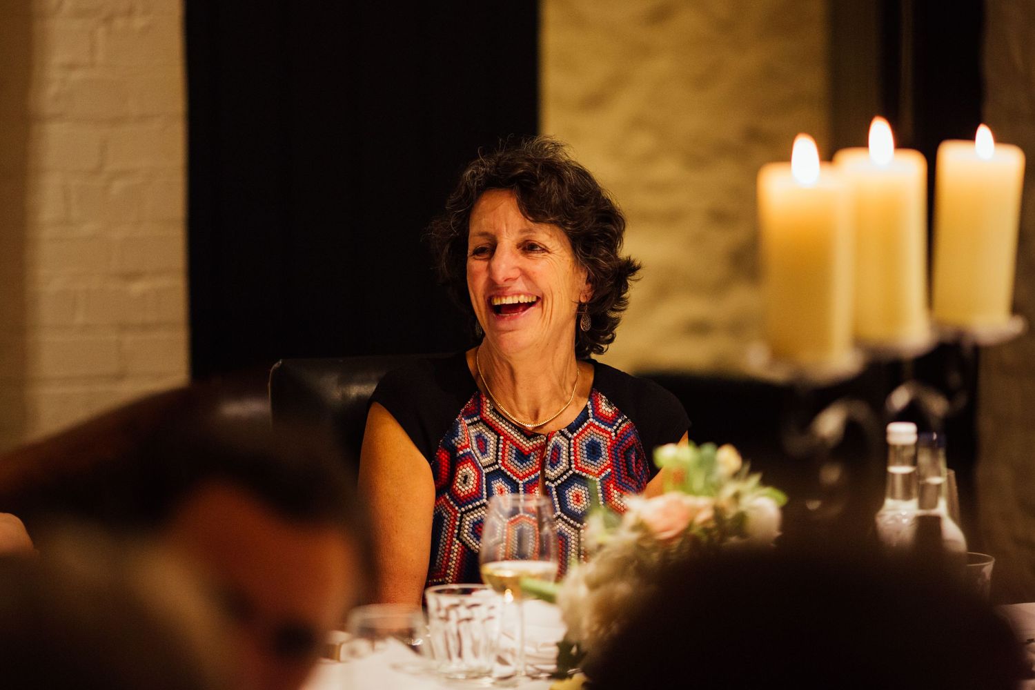 A candlelit dinner table in a rustic restaurant setting creates a warm and intimate atmosphere.