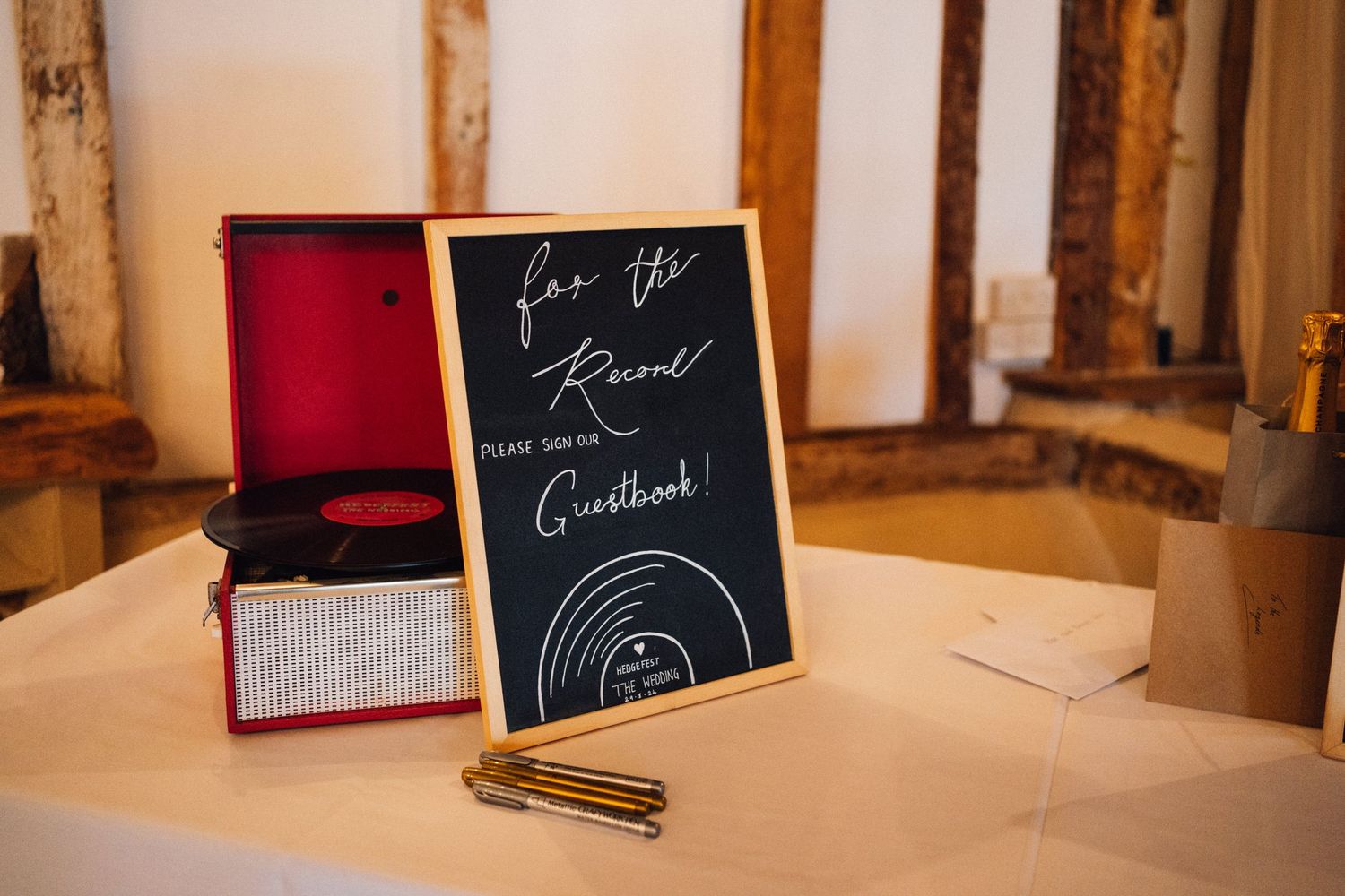 Wooden reception tables set with chalkboard signs and rustic decor in a barn wedding venue.