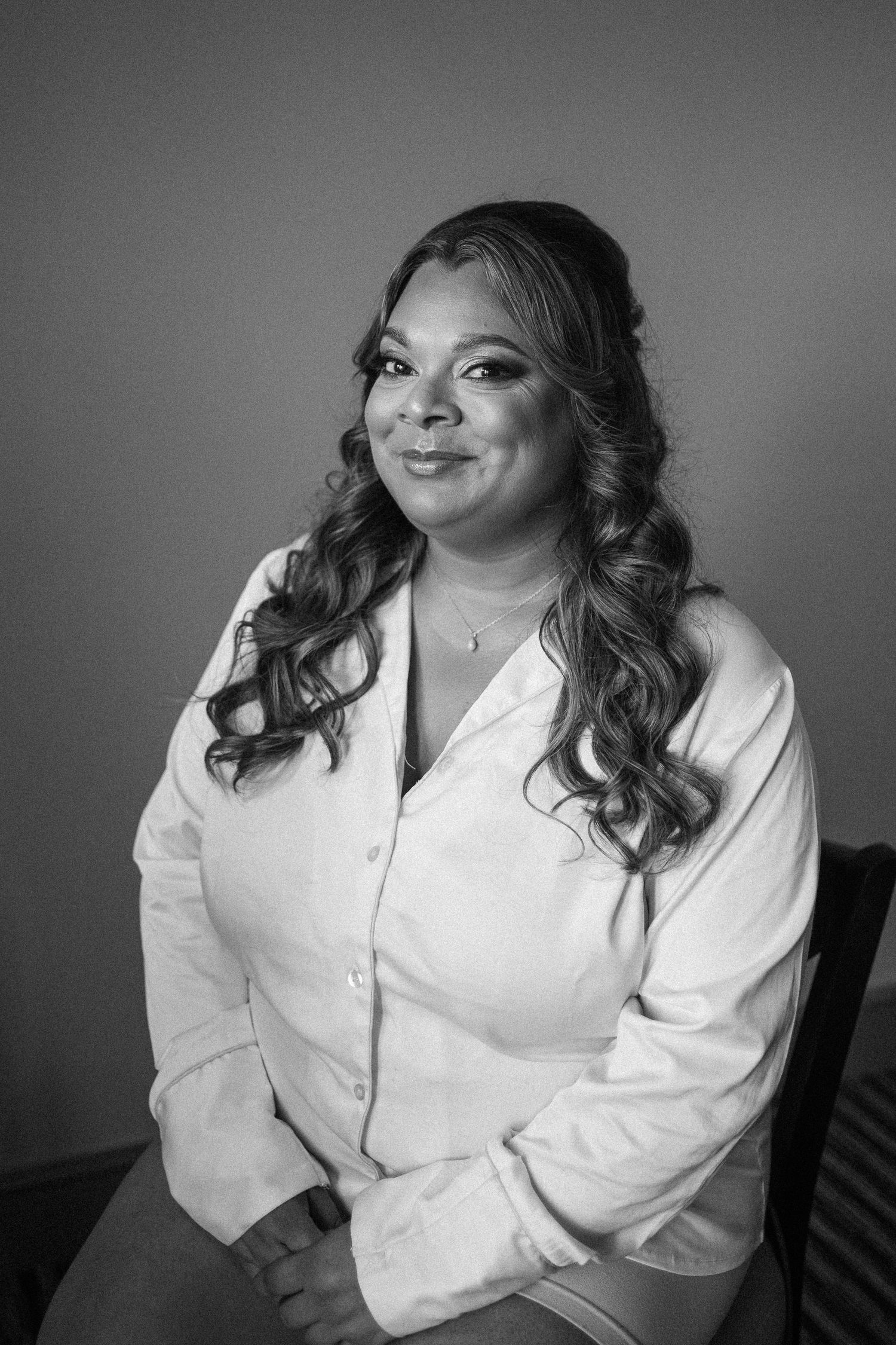 Black and white portrait series showing a person in a white button-down shirt posing against a dark background.