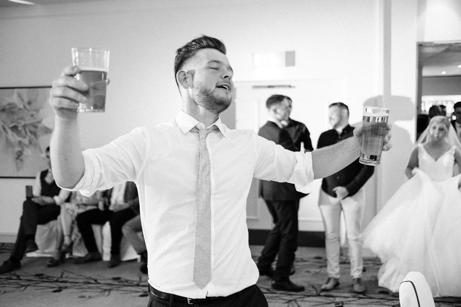 Black and white photos showing guests dancing and celebrating at a wedding reception.