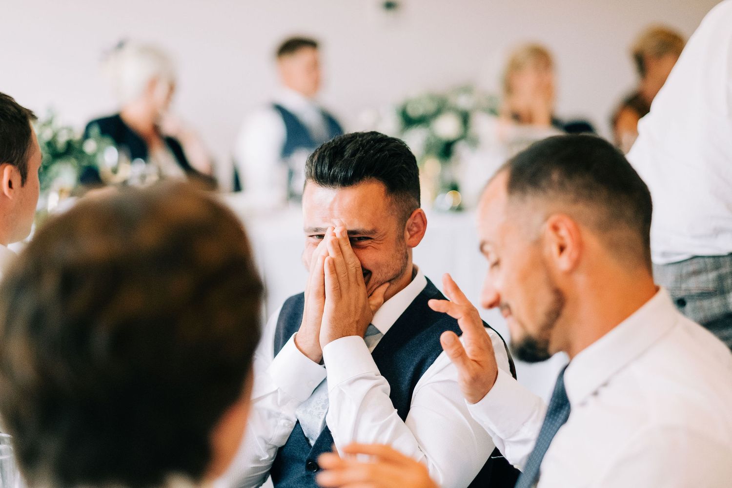 Wedding guests share laughter and conversation during an elegant reception celebration.