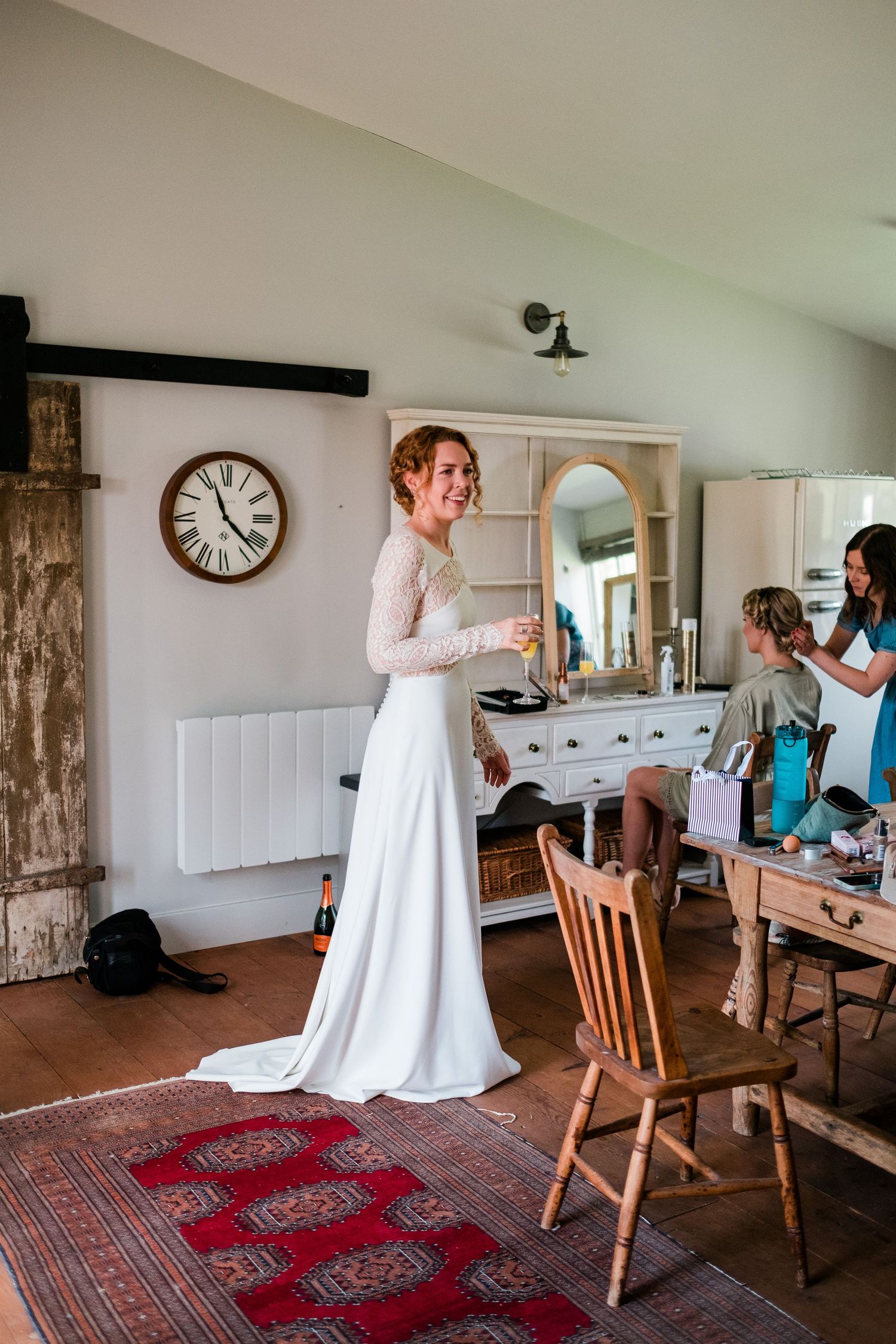 Bridal preparation in a rustic room with wooden furniture and vintage decor.