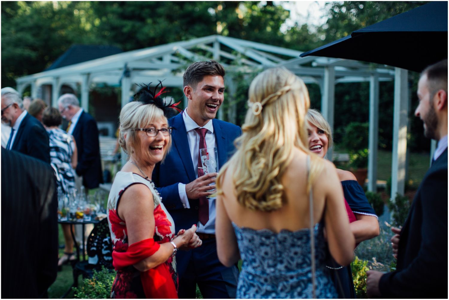 Wedding guests enjoying drinks and conversation at an outdoor event.