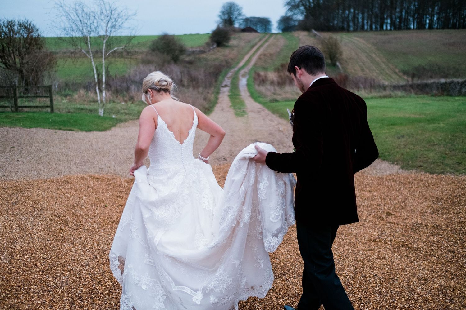 Romantic wedding photo sequence showing couple walking along a gravel pathway in a rural setting.