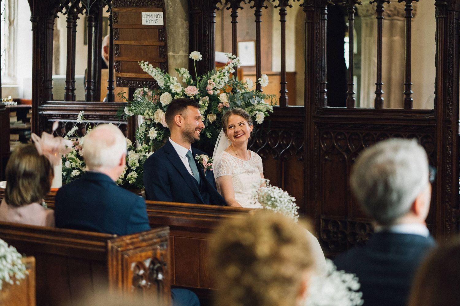 Wedding ceremony in progress at a historic church with gothic details and stained glass windows.