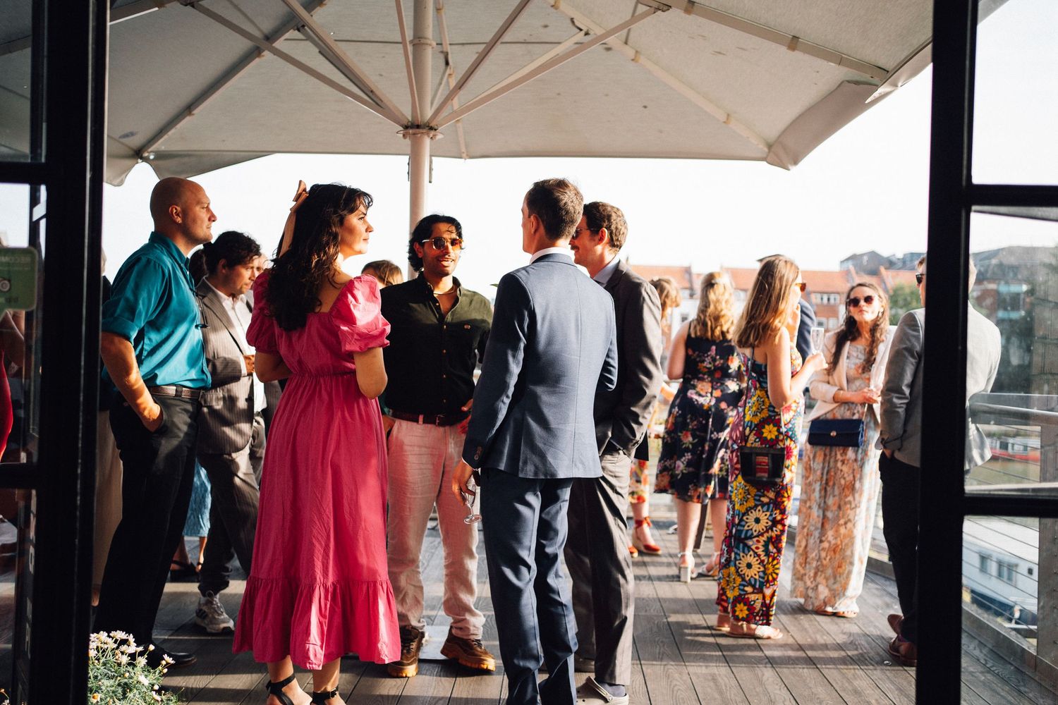 Wedding guests mingling under a white tent during an outdoor reception.