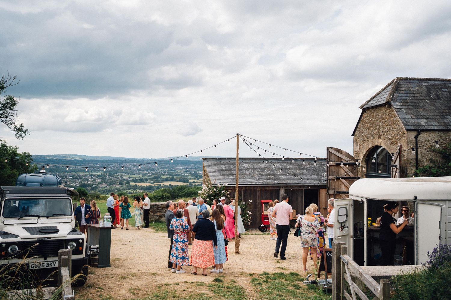 Wedding reception venue with tents and decorations overlooking a scenic countryside view.