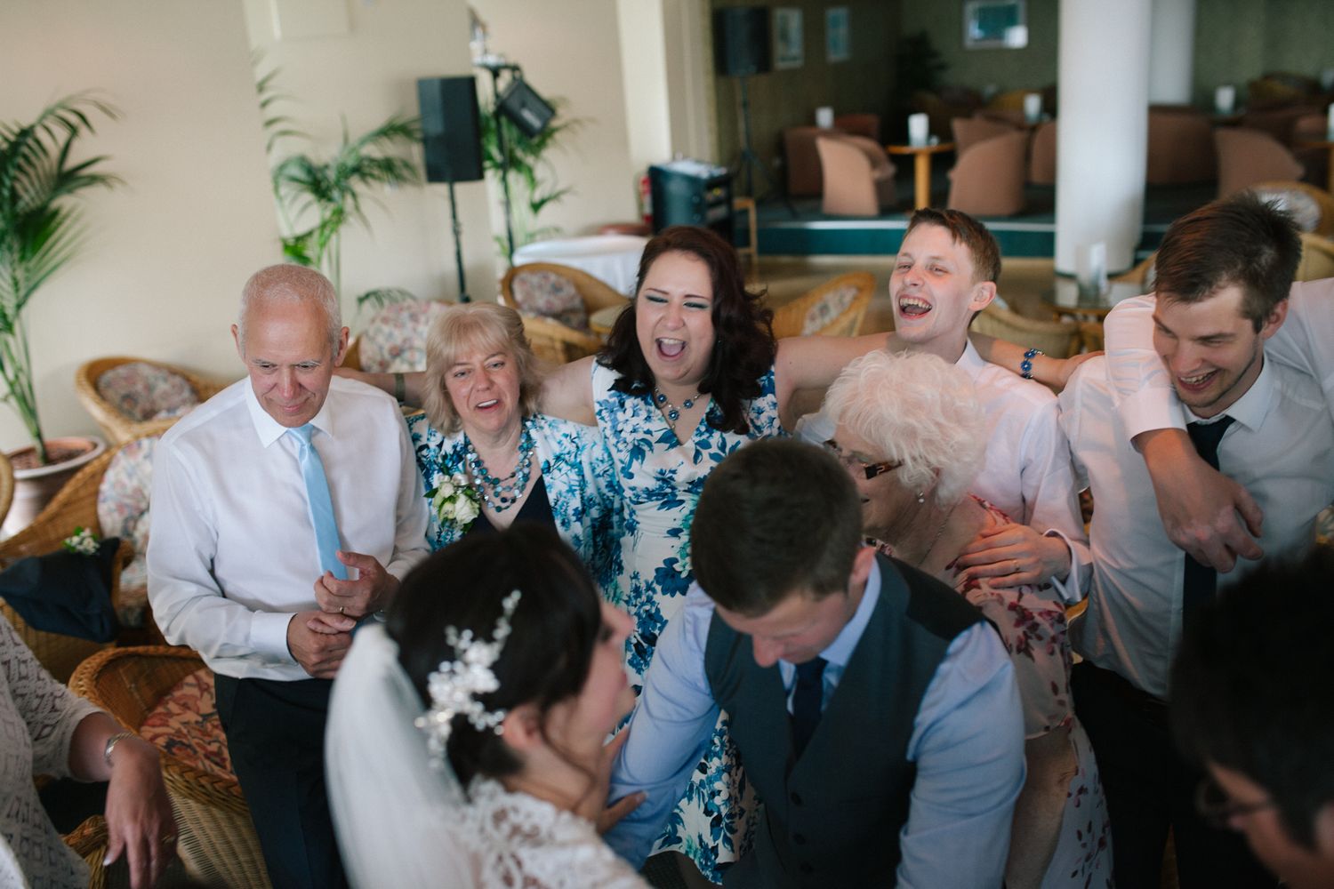 Wedding guests dancing and celebrating during an indoor reception party.