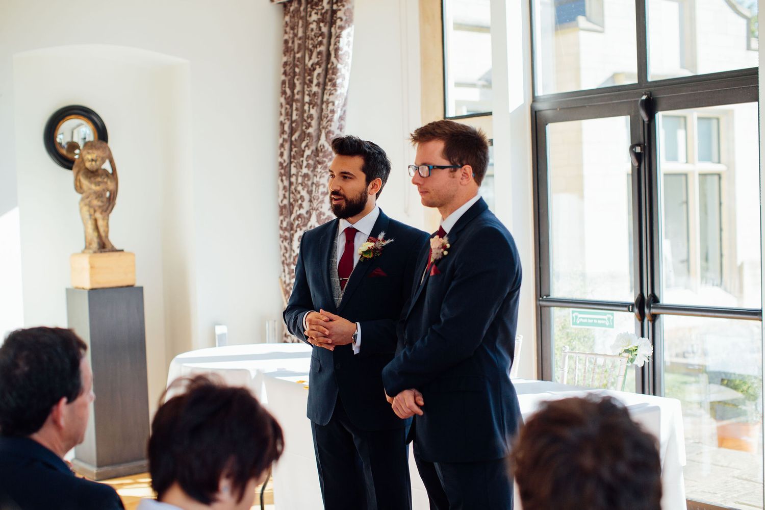Wedding celebration captured in a bright indoor venue with large windows.
