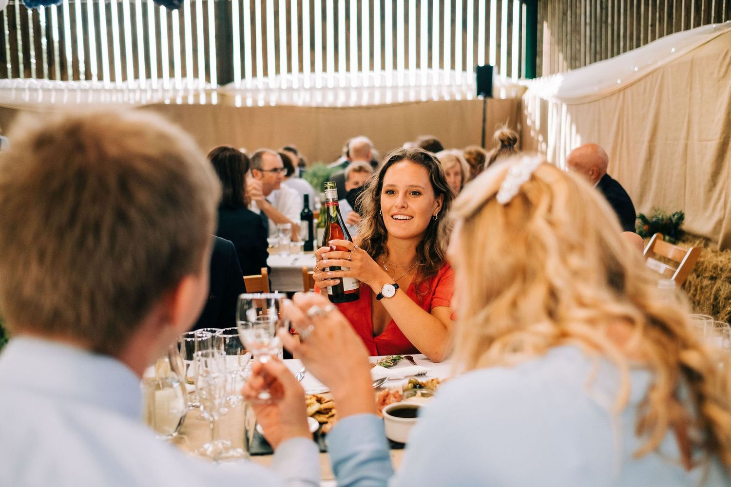 Guests seated at long tables during an outdoor wedding reception.