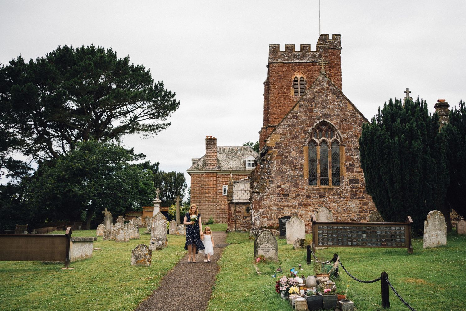 Historic brick church with tower photographed against cloudy sky.