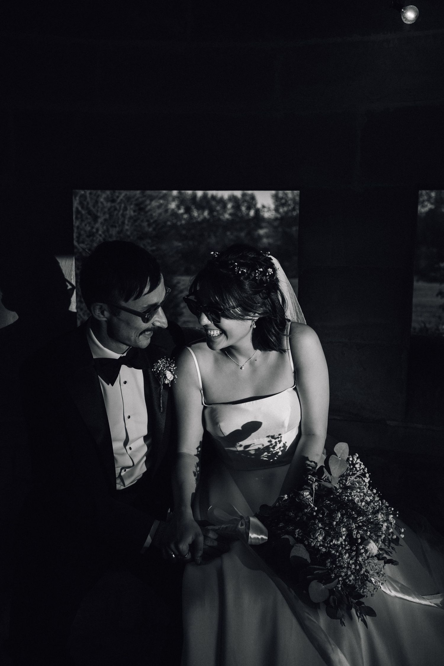 Artistic black and white shot of wedding details in dramatic lighting.