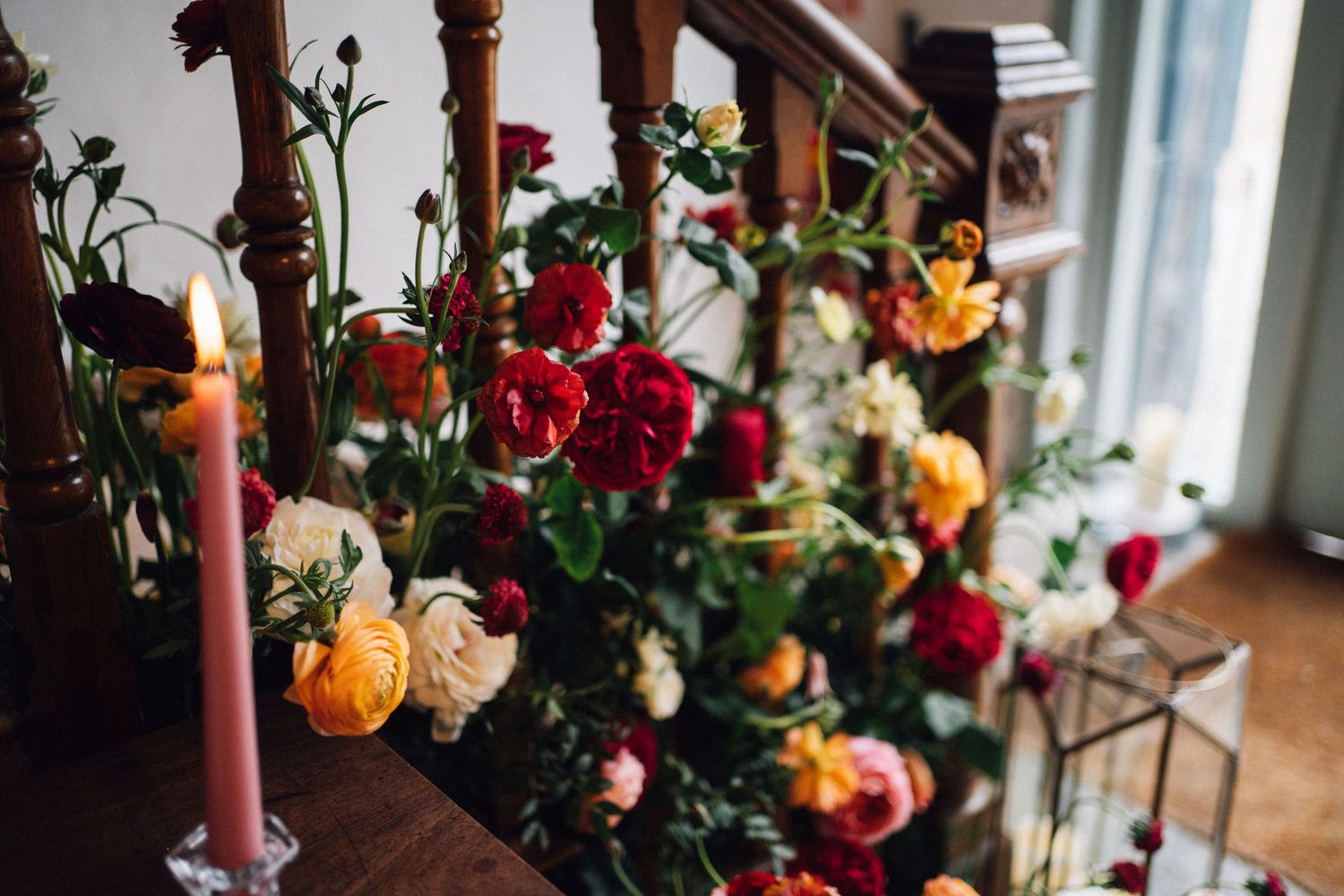 Lush floral arrangements with vibrant roses and mixed flowers decorating a wedding venue.