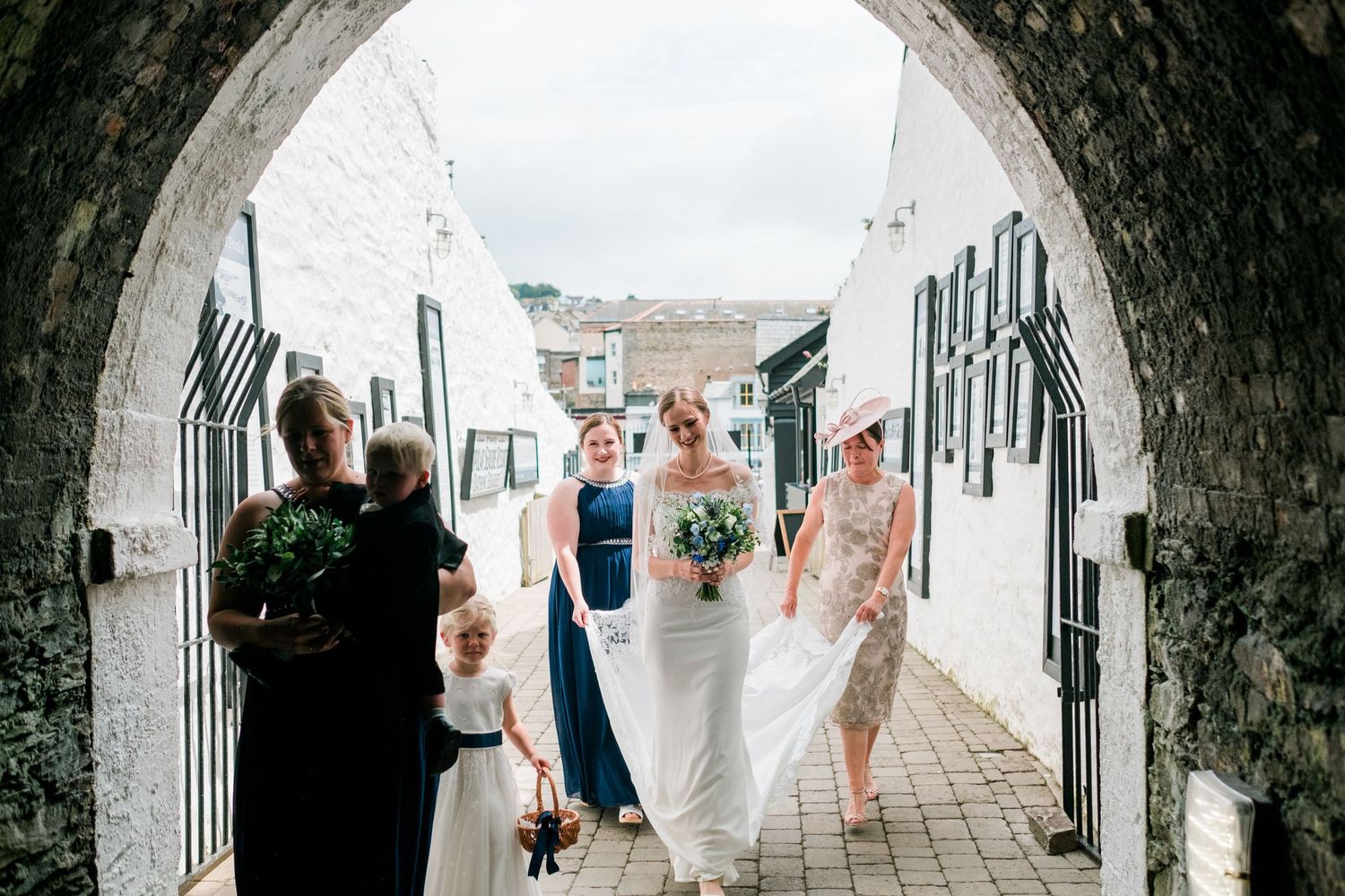 Stone archway corridor with hanging bunting and natural light streaming through.